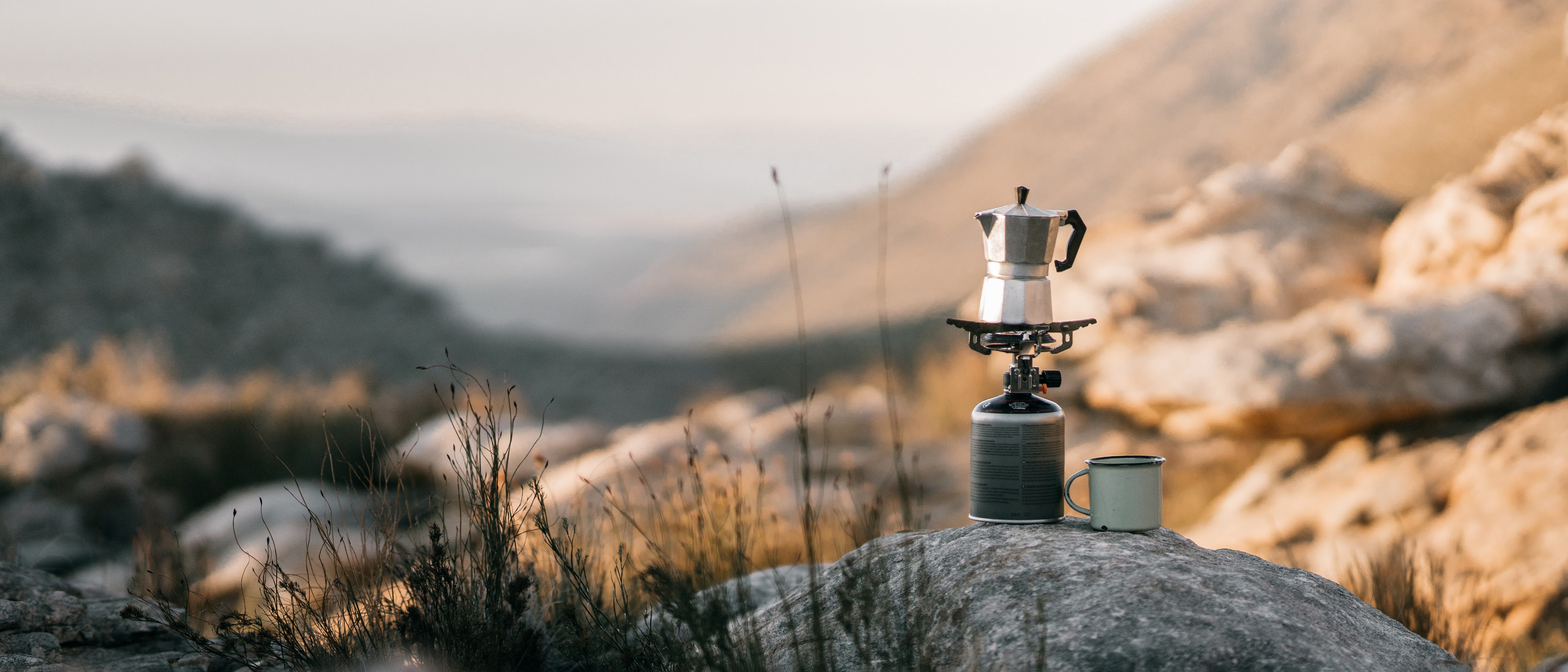 brewing a coffee in the countryside on a solo camping trip