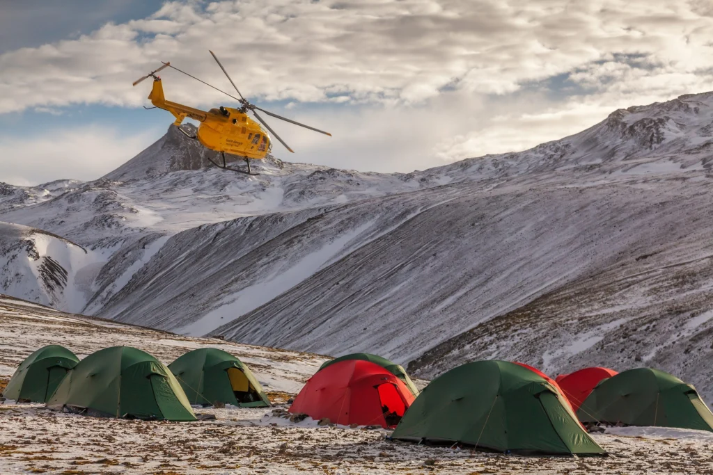 helicopter flying over a number of blizzard tents