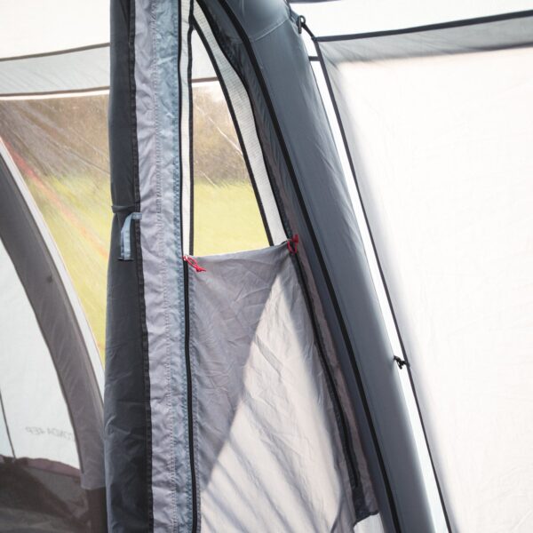 44ZON4E-Zonda-4EP-inner-window-2-1500x1500-1-1.jpg Interior view of a grey tent panel showing a vertical zippered entrance, a mesh window and a small fabric storage pocket tied with red toggle cords.