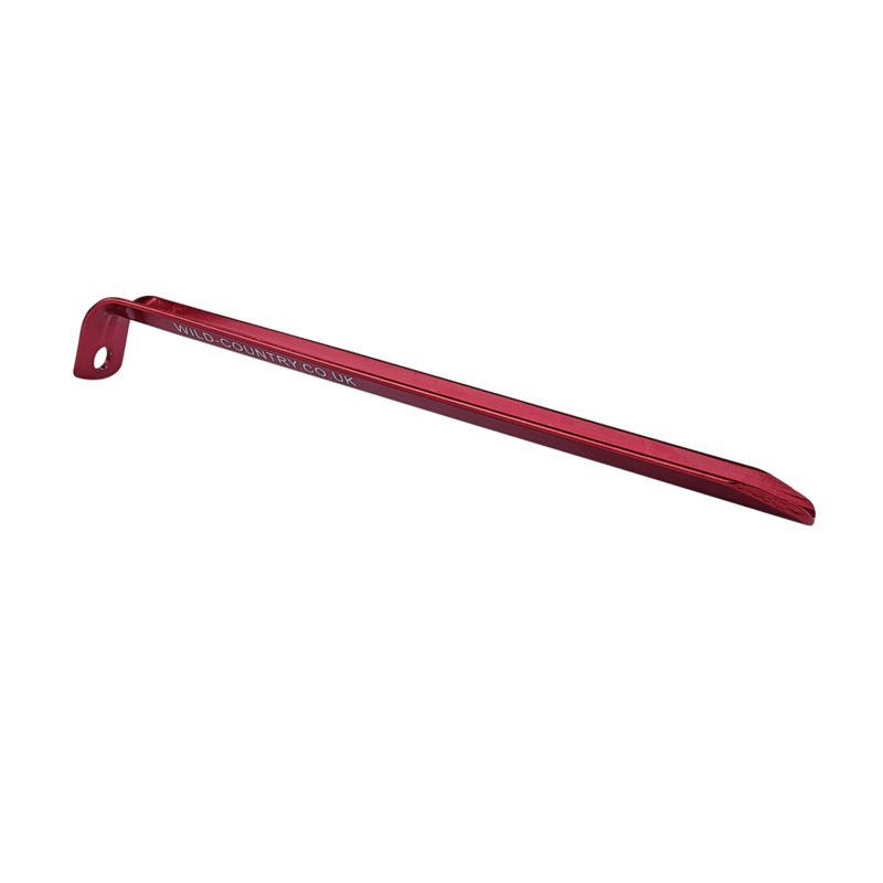 Red anodised aluminium tent peg with a hooked top featuring a hole and a tapered chisel end, 'wild-country.co.uk' printed along the shaft, shown on a white background.