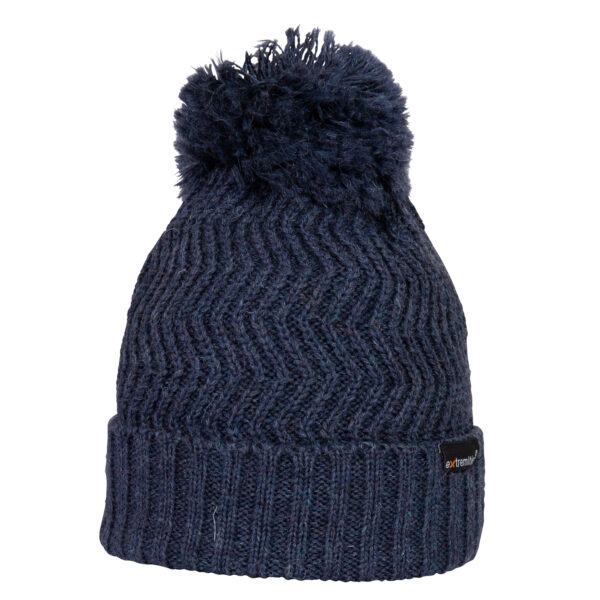 Dark navy knitted winter beanie with a folded ribbed cuff, chevron stitch pattern and a large fluffy pom-pom on top, with a small black brand tag on the cuff.