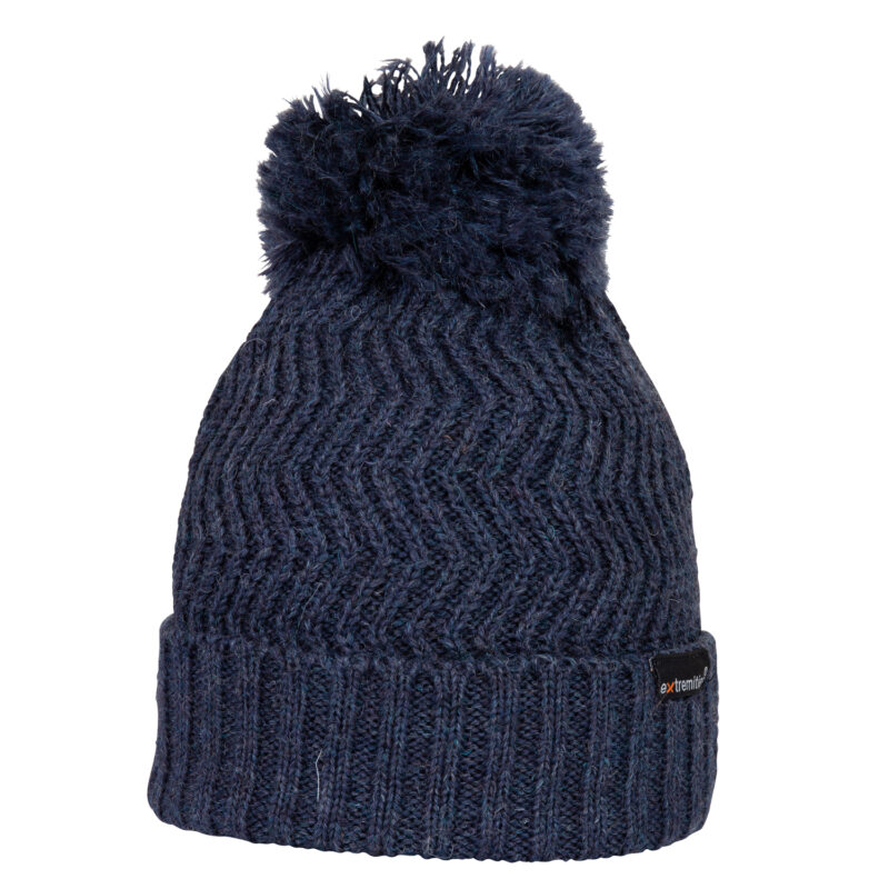 Castleton-Beanie-Denim-Cut-Out-300dpi-1.jpg Dark navy knitted winter beanie with a folded ribbed cuff, chevron stitch pattern and a large fluffy pom-pom on top, with a small black brand tag on the cuff.