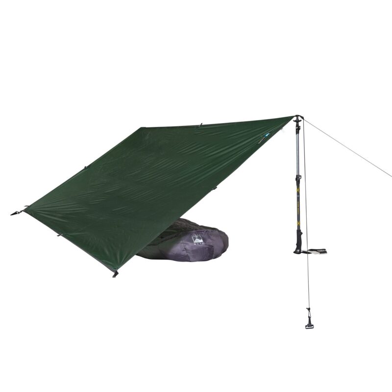 Competition-tarp-1-back-square-4.jpg Dark green rectangular camping tarp set up as an angled lean-to on a white background, tensioned with a trekking pole and guy line and sheltering a grey compressed sleeping bag underneath