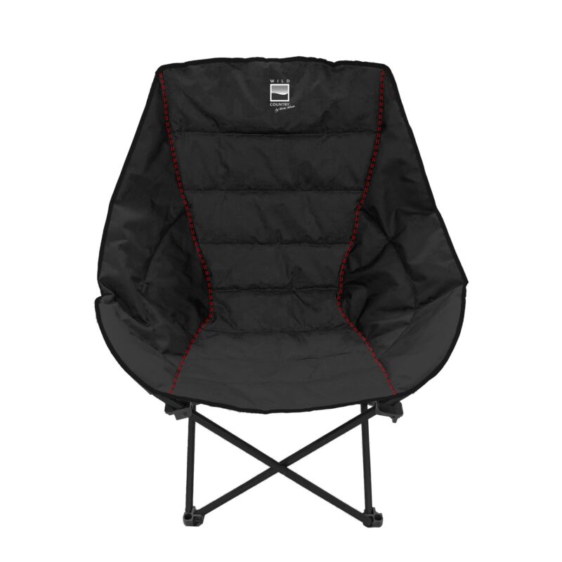 Black padded folding camping chair with quilted panels, red contrast stitching and a small WILD COUNTRY logo on the headrest, formed in a rounded bowl shape on a collapsible black metal X-frame.
