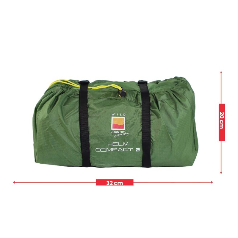 Green packed tent bag labeled WILD COUNTRY HELM COMPACT 2 with black compression straps and a yellow drawstring, shown with red measurement arrows indicating 32 cm width and 20 cm height.