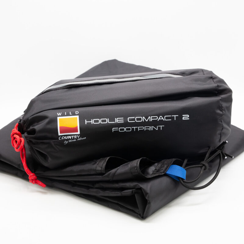Hoolie-Compact-2-2-3.jpg Black folded tent footprint in its storage bag labelled HOOLIE COMPACT 2 FOOTPRINT with a Wild Country logo, red drawcord and blue attachment loop on a white background