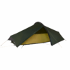 Low-profile dark green single-person tunnel tent staked and guyed out with a partially open entrance revealing a yellow inner bivvy on a white background