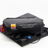 Norte-Compact-1-2-3.jpg Black folded tent footprint and cylindrical stuff sack on a white background, labelled 'NORTE COMPACT 1 FOOTPRINT' with a Wild Country by Terra Nova logo, red drawcord and blue attachment tab visible.