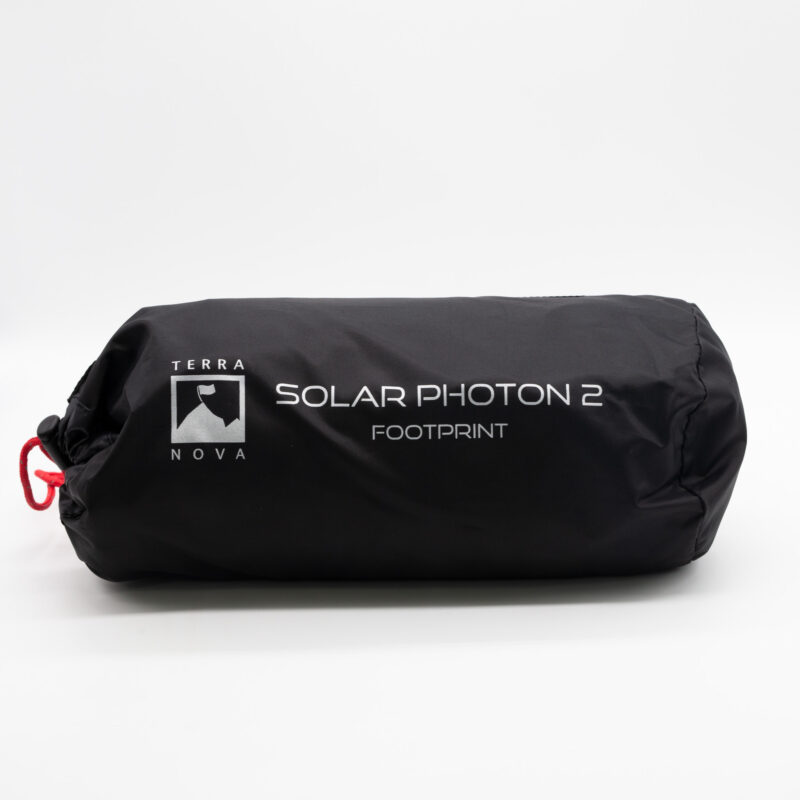 Solar-Photon-2-1-5.jpg Black cylindrical stuff sack bearing the Terra Nova logo and white text 'SOLAR PHOTON 2 FOOTPRINT', cinched closed with a red drawcord.