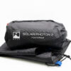 Solar-Photon-2-2-3.jpg Black packed storage bag printed with 'Terra Nova Solar Photon 2 Footprint' resting on folded black footprint fabric with a visible blue webbing pull tab and drawcord.
