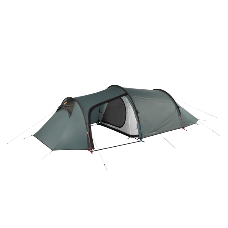 Green-grey tunnel-style camping tent with two connected sleeping compartments and a central covered entrance showing an inner mesh door, arched poles, guy lines and pegs