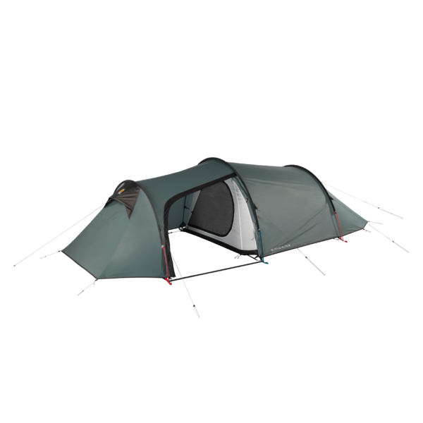 Green-grey tunnel-style camping tent with two connected sleeping compartments and a central covered entrance showing an inner mesh door, arched poles, guy lines and pegs