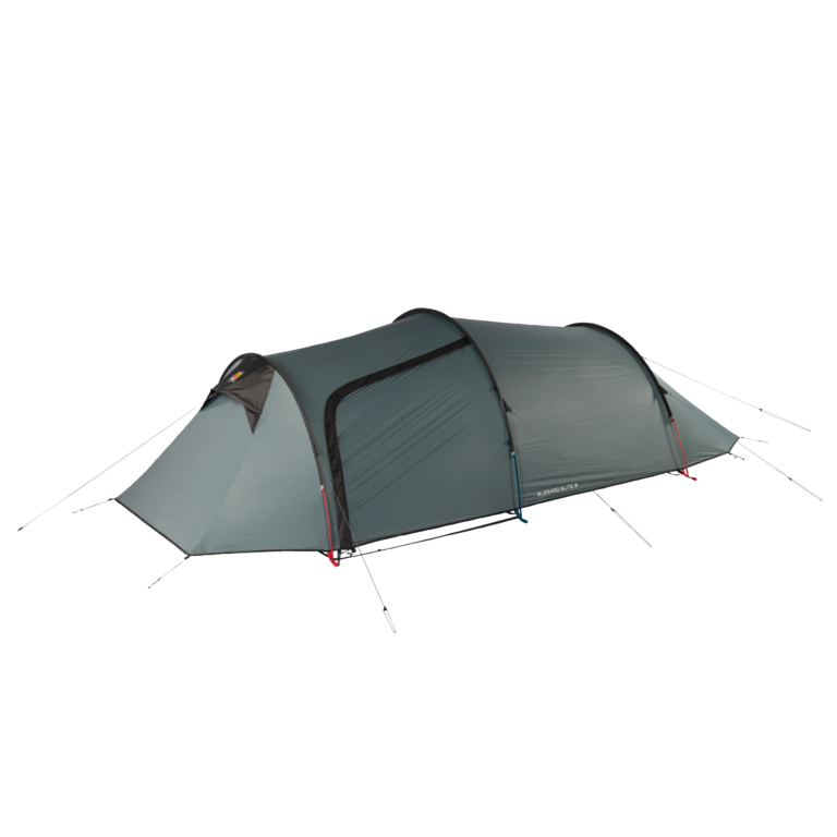 Green-grey, low-profile three-person tunnel tent with arched poles, a front vestibule and a zippered side door, secured with red and blue guy lines on a plain background.