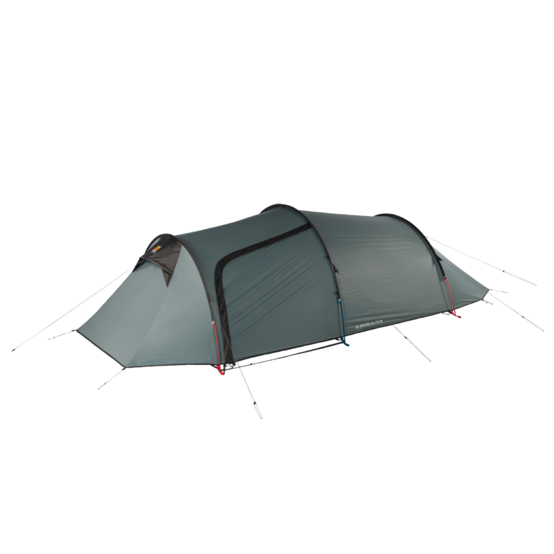 Green-grey, low-profile three-person tunnel tent with arched poles, a front vestibule and a zippered side door, secured with red and blue guy lines on a plain background.