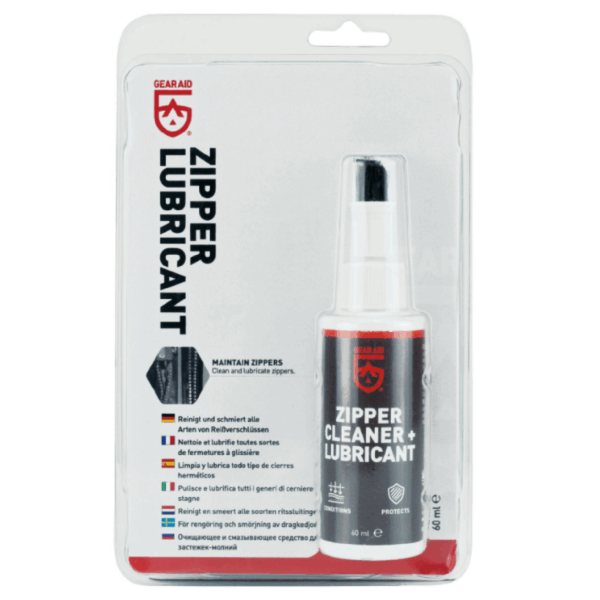 Blister-packaged 60 ml Gear Aid zipper cleaner and lubricant spray bottle with a grey label and red logo, shown on a backing card featuring bold vertical 'ZIPPER LUBRICANT' text.