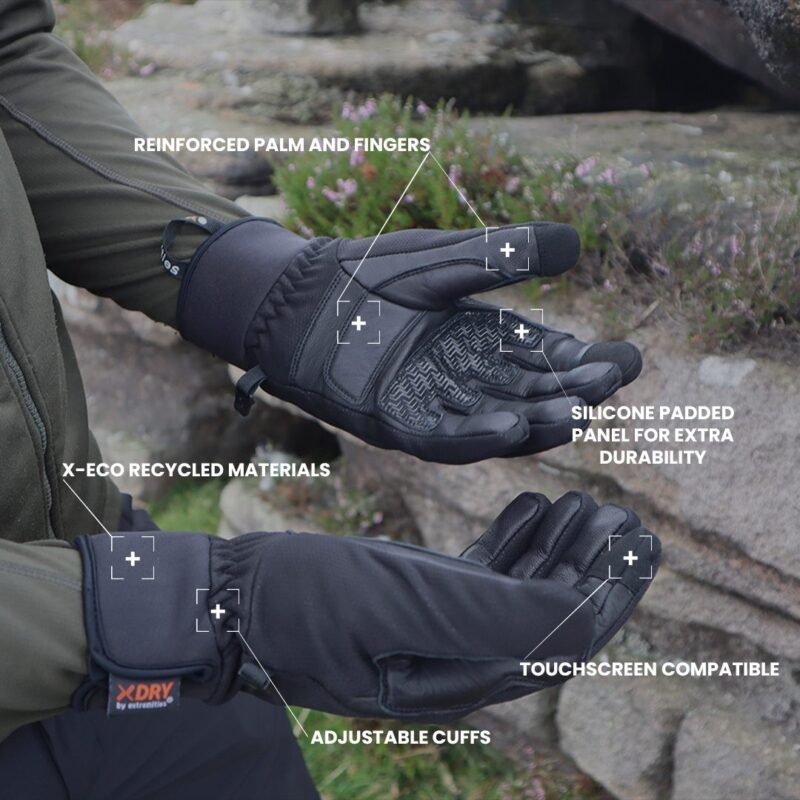 belay-gloves-product-spec-copy-3.jpg Black insulated outdoor gloves shown palm-up and palm-down on a rocky background with annotated labels highlighting reinforced palm and fingers, silicone-padded panel for durability, touchscreen compatibility, adjustable cuffs and X‑ECO recycled materials with an XDRY tag visible.