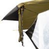 Close-up of a trekking pole used as a tent pole supporting an olive-green rainfly and white tent wall, with yellow guy lines, black straps and clips securing the fabric.