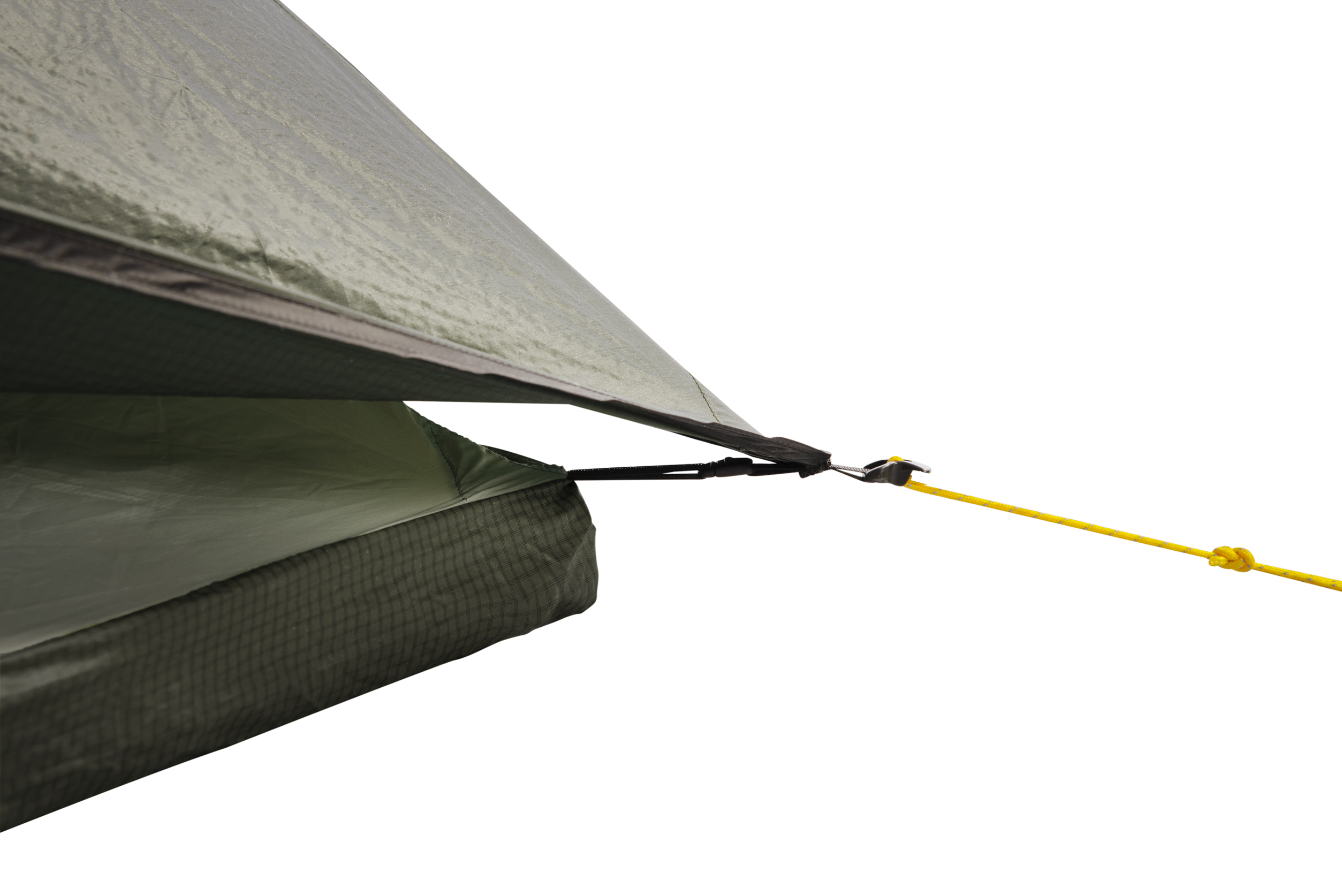 Close-up of a green ripstop tent fly corner showing overlapping inner fabric, a black webbing attachment clipped into a small plastic cord tensioner and a yellow guyline tied in a knot against a white background