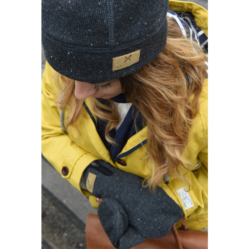 zoom_Furnace_Beanie_1-1.jpg Top-down view of a person in a bright yellow coat with long wavy reddish-blonde hair, wearing a dark grey knit beanie with a tan leather patch and matching mittens while looking down.