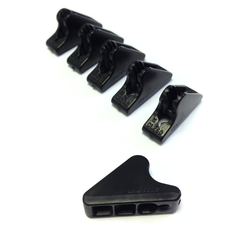 Six black plastic rope cleats on a white background: five cam-style cleats arranged diagonally in a row and one triangular base piece with three rectangular cable slots.
