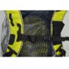 zoom_Laser_Ultra_5_Pack_3-1.jpg Close-up of a backpack harness showing a central black plastic chest buckle and adjustable webbing across a padded mesh back panel with yellow trim, dotted ventilation pattern and silver-edged fabric.