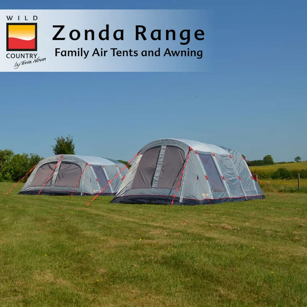 Two family-sized air tents from the Zonda Range by Wild Country set up on a grassy field under a clear blue sky, showcasing their spacious design and ventilation features.